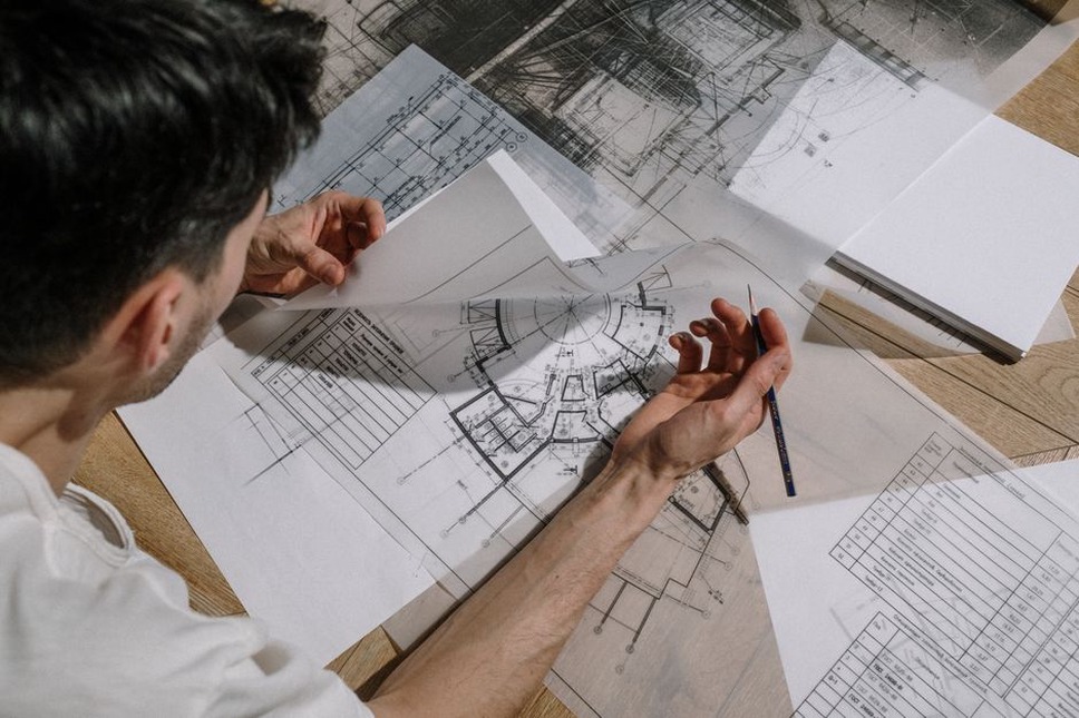 Architect examining detailed building plans on site