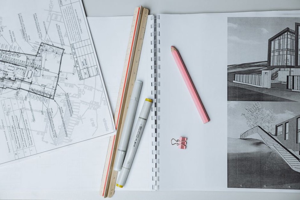 Detailed architectural blueprints spread across a desk
