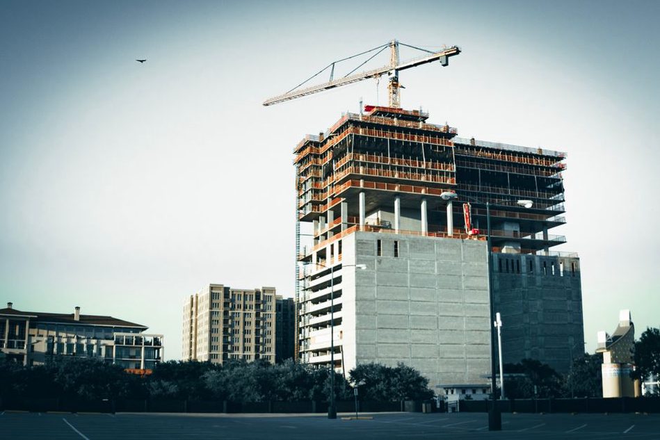 A commercial building under construction with cranes and scaffolding