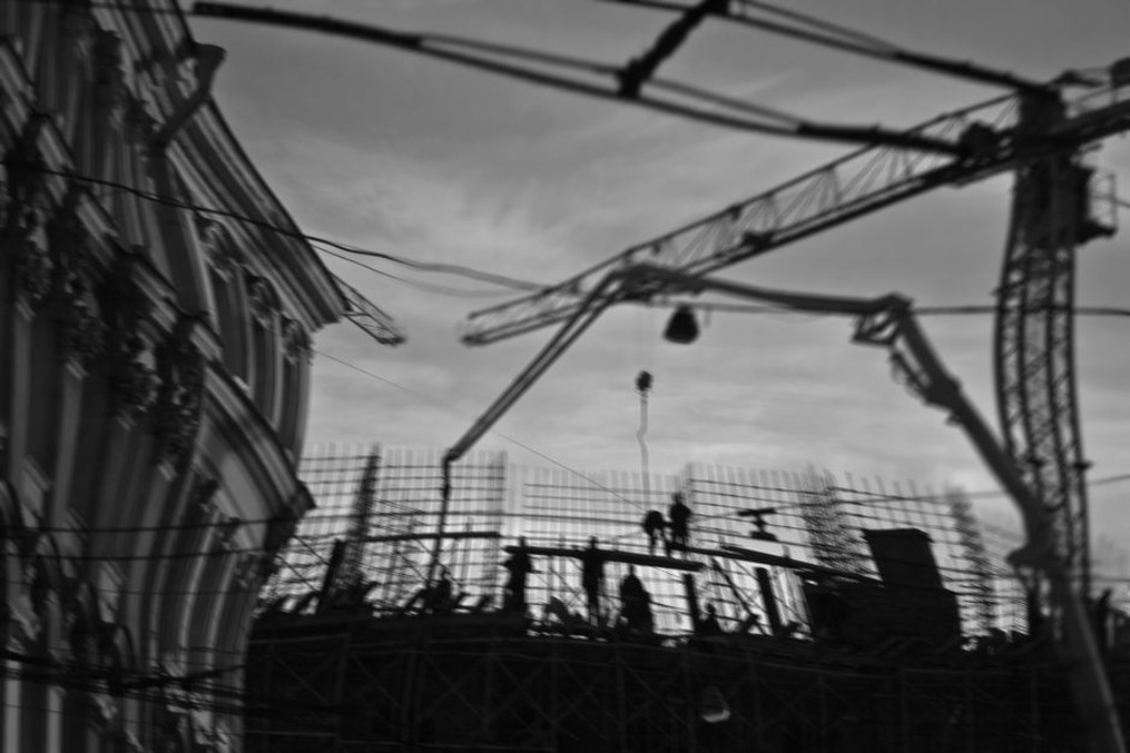 Construction site bustling with activity under cranes