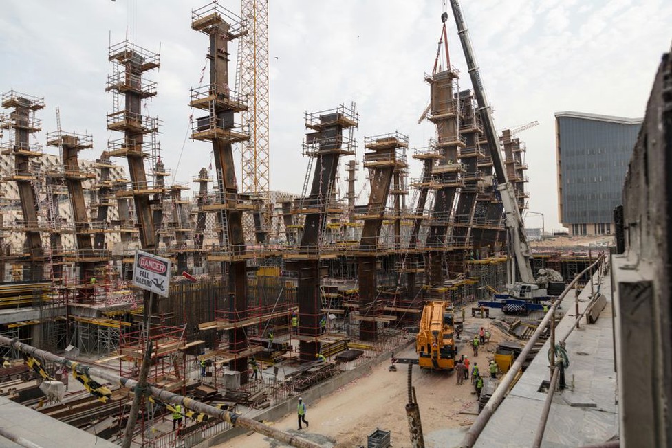 Construction site with cranes and workers bustling around