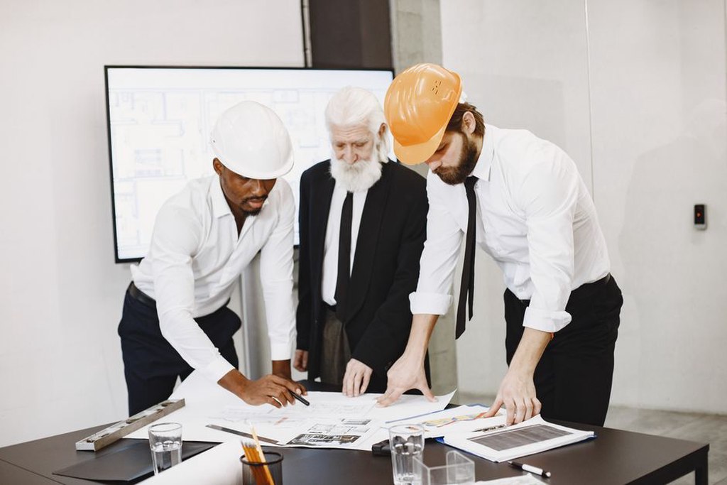 Design team compares building layouts around a table