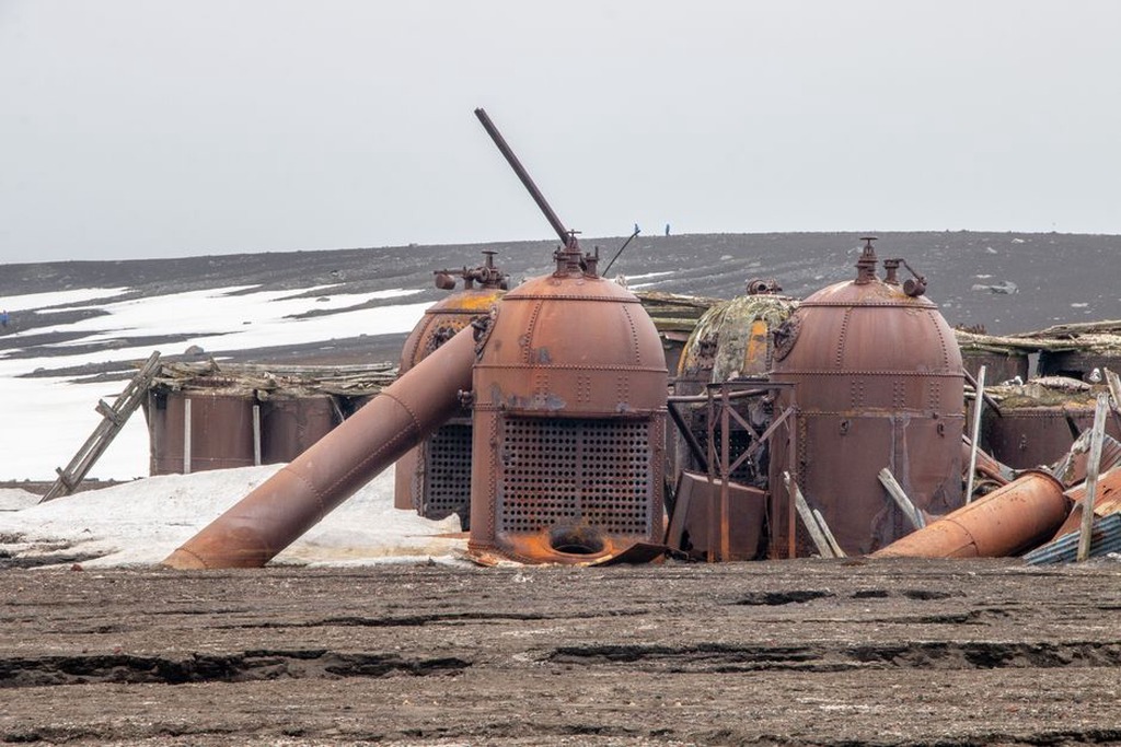 elevated building on steel pilings above frozen ground with heat-transfer tubes