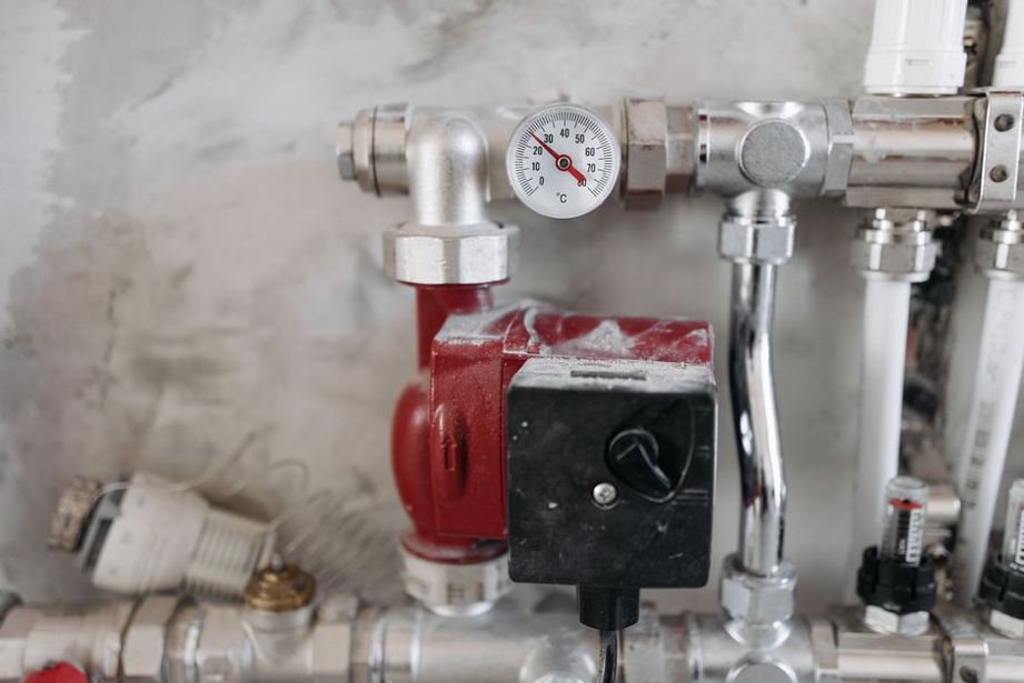 Heat-pump units and labeled pipework in a plant room