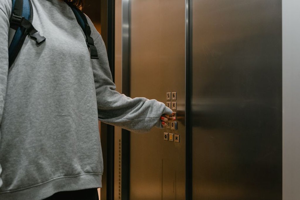elevator cab showing braille control panel and support rail in a public facility