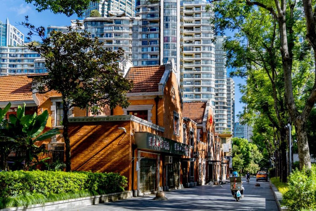 Pedestrians and cyclists move past a mixed-use building