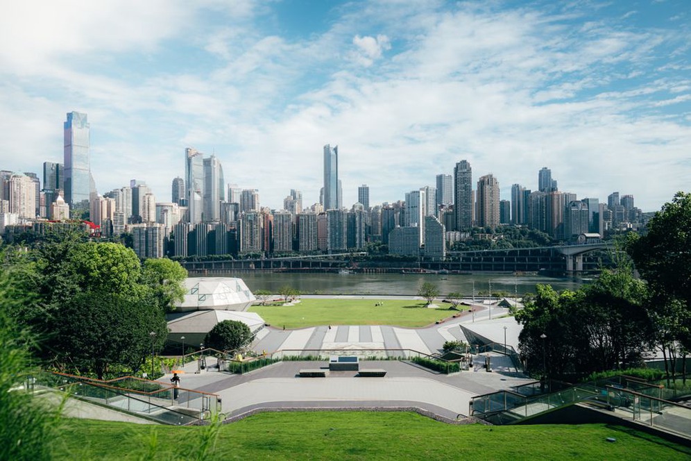 A city park surrounded by tall buildings, offering a green oasis in a densely populated area