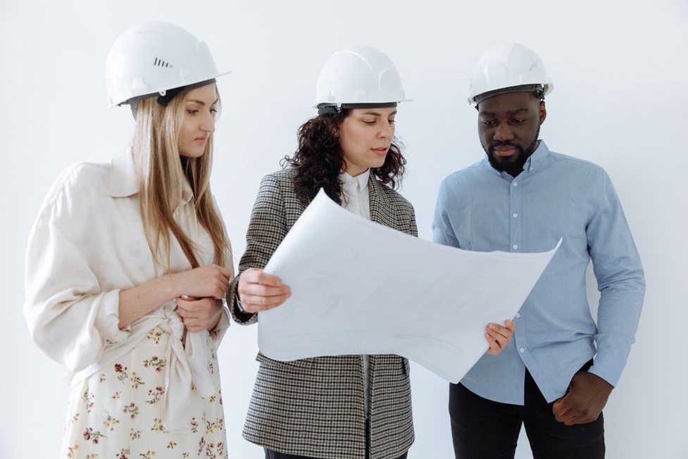 Designers compare plans across a shared project table