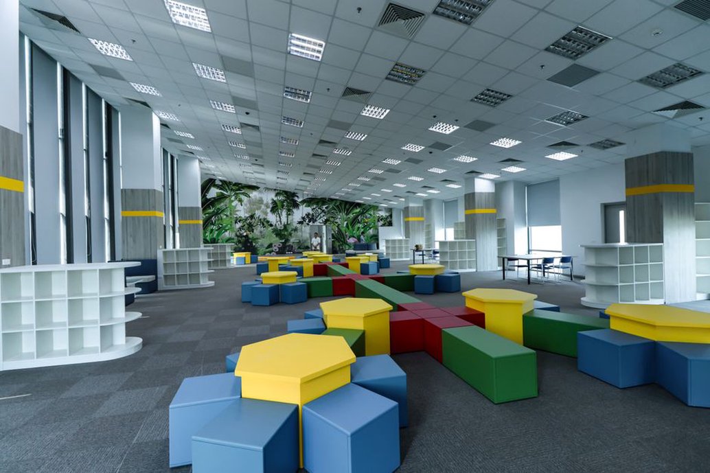 Movable tables beneath shaded classroom windows