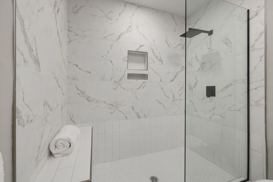 Bottles sit inside a tiled shower recess