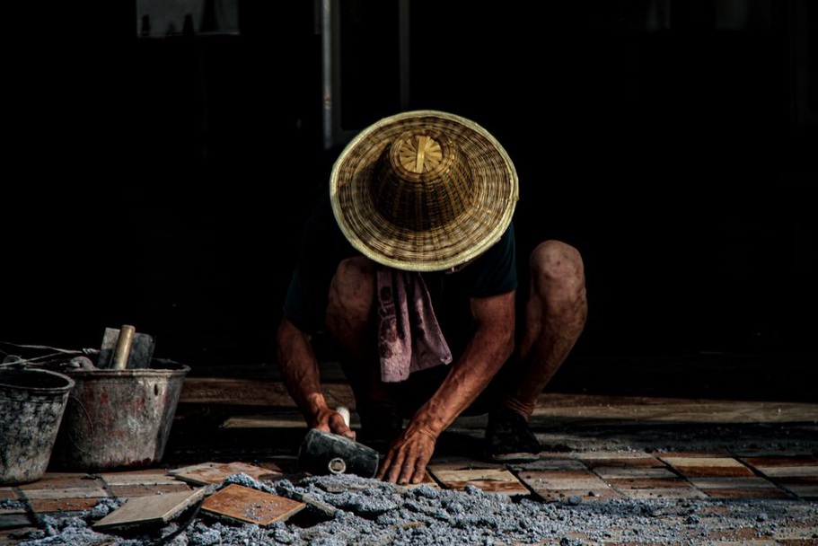 Mason setting stone units along an exterior wall